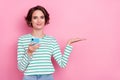 Portrait of attractive cheery girl holding on palm copy space using gadget app media post isolated over pink pastel