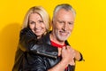 Portrait of attractive cheery pensioner grey-haired friendly lovers having fun embracing over bright yellow