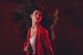 Portrait of attractive chic woman posing air flying isolated over dark red light color background Royalty Free Stock Photo