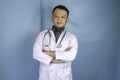 Portrait of an attractive confident male doctor, friendly smiling arms crossed wear white lab coat stethoscope isolated blue color Royalty Free Stock Photo