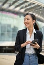 Confident Asian businesswoman using her smartphone at outside of the company building Royalty Free Stock Photo