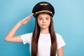Portrait of attractive content serious girl captain wearing hat headwear posing isolated over bright blue color