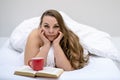 Portrait of an attractive, contented, young, plus size, fat, overweight, chubby, sexy long haired woman lying relaxed in bed Royalty Free Stock Photo