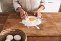 Portrait of attractive couple wearing aprons cooking pastry with flour and eggs in kitchen at home