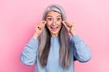 Portrait of attractive crazy cheerful grey-haired woman granny touching specs isolated over pink pastel color background Royalty Free Stock Photo