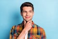 Portrait of attractive curious pensive cheerful guy touching chin making decision over bright blue color