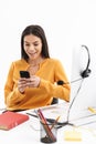 Portrait of attractive customer supporter woman using smartphone while working in call center Royalty Free Stock Photo