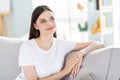 Portrait of attractive dreamy brunette girl sitting on divan resting spending day thinking at home indoors Royalty Free Stock Photo