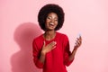 Portrait of attractive dreamy cheerful girl using gadget laughing having fun isolated over pink pastel color background