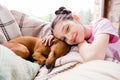 Portrait of attractive dreamy cheery preteen girl resting with cute doggy puppy spending time staying alone at light