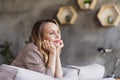 Portrait of attractive dreamy girl sitting on divan thinking spending weekend free spare time at industrial style Royalty Free Stock Photo