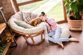 Portrait of attractive dreamy kind sweet preteen girl resting with cute doggy puppy staying alone at wooden interior