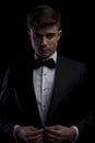Portrait of attractive elegant man buttoning his black tuxedo Royalty Free Stock Photo
