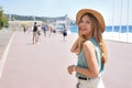 Portrait of attractive fashion woman turns around and smiling at camera walking along Promenade des Anglais, Nice, France Royalty Free Stock Photo