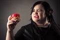 Portrait attractive fat woman eating red hamburger