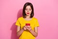 Portrait of attractive focused girl using device gadget chatting post isolated over pink pastel color background