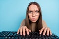 Portrait of attractive focused tense funny girl typing playing strategy game solving problem isolated over bright blue Royalty Free Stock Photo