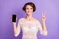 Portrait of attractive friendly lady demonstrate display fingers show v-sign on purple color background