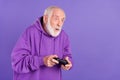 Portrait of attractive funky amazed man playing game pastime hobby isolated over bright violet purple color background Royalty Free Stock Photo