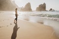 Portrait of attractive girl with light brown hair posing on rocky Ursa beach on sunset. Smiling looking to the camera Royalty Free Stock Photo