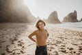 Portrait of attractive girl with light brown hair posing on rocky Ursa beach on sunset. Smiling looking to the camera Royalty Free Stock Photo