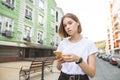 Portrait attractive girl standing with a smartphone in his hands and headphones on the background Royalty Free Stock Photo