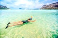 Portrait of attractive girl wearing black swimsuit and snorkling in clear ocean water