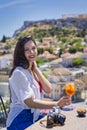 Portrait of a Greek girl enjoying a drink overlooking the Acropolis of Athens Royalty Free Stock Photo