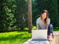 Portrait of attractive happy woman with laptop outdoors. Online education Royalty Free Stock Photo