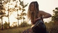 Portrait of an attractive hippie woman with dreadlocks in the woods at sunset having good time outdoorsBeautiful young hippie woma