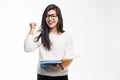 Portrait of attractive indian student woman standing holding reading a book with win gesture over white background. Education test Royalty Free Stock Photo