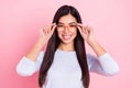 Portrait of attractive intellectual cheerful girl wearing touching specs isolated over pink pastel color background