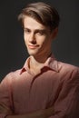 Portrait of attractive kind young man with folded and crossing hands standing Isolated on black background and looking