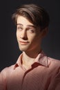 Portrait of attractive kind young man rolled his eyes in stripped shirt. Isolated on black background and looking at Royalty Free Stock Photo