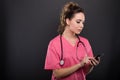 Portrait of attractive lady doctor texting on smartphone Royalty Free Stock Photo