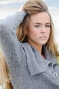 Portrait of the attractive lovely woman sits in the sand dune of a beach relaxing - autumn, beach, sea. Woman in the sand dunes Royalty Free Stock Photo