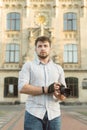 Portrait of attractive male photographer outdoors at european architecture background. Young handsome man with beard holding Royalty Free Stock Photo