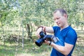 Portrait of attractive male photographer at work looks to camera. Summer day. Young man with a DSLR camera in hands. One person po Royalty Free Stock Photo