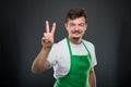 Portrait of attractive male supermarket employer showing peace g