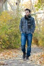 Portrait of attractive man dressed in casual wear, have a rest oudoor in autumn park Royalty Free Stock Photo