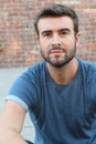 Portrait of attractive man on red brick wall background / Closeup of young interesting natural male