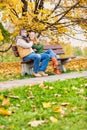 Portrait of attractive man sitting on bench while talking to his beautiful wife in park Royalty Free Stock Photo