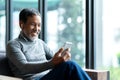 Portrait of attractive mature asian man retired with stylish short beard using smartphone sitting or listening music in urban life