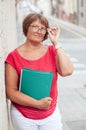 Portrait of attractive mature woman with a business folder and glasses. Royalty Free Stock Photo