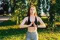 Portrait of attractive meditative young woman with closed eyes performing making hand namaste