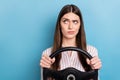 Portrait of attractive minded skeptic girl riding car thinking copy space isolated over shine blue color background