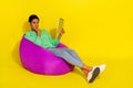 Portrait of attractive minded skeptic girl using ebook reading studying over bright yellow color background