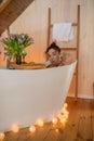 Portrait of attractive naked woman relaxing and spending weekend at home. Taking bath with glass of wine on food tray Royalty Free Stock Photo