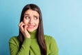 Portrait of attractive nervous girl biting nails expecting bad news looking aside copy space isolated over bright blue Royalty Free Stock Photo