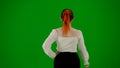 Portrait of attractive office girl on chroma key green screen. Woman in skirt and blouse walking cutely. Back view.